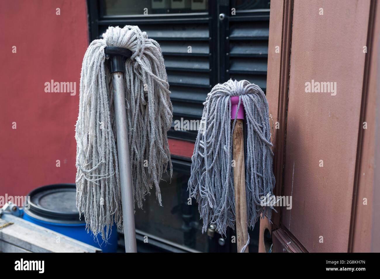07.07.2017, Singapore, Republic of Singapore, Asia - Two damp floor mops lean against a window for drying in the city district of Chinatown. Stock Photo