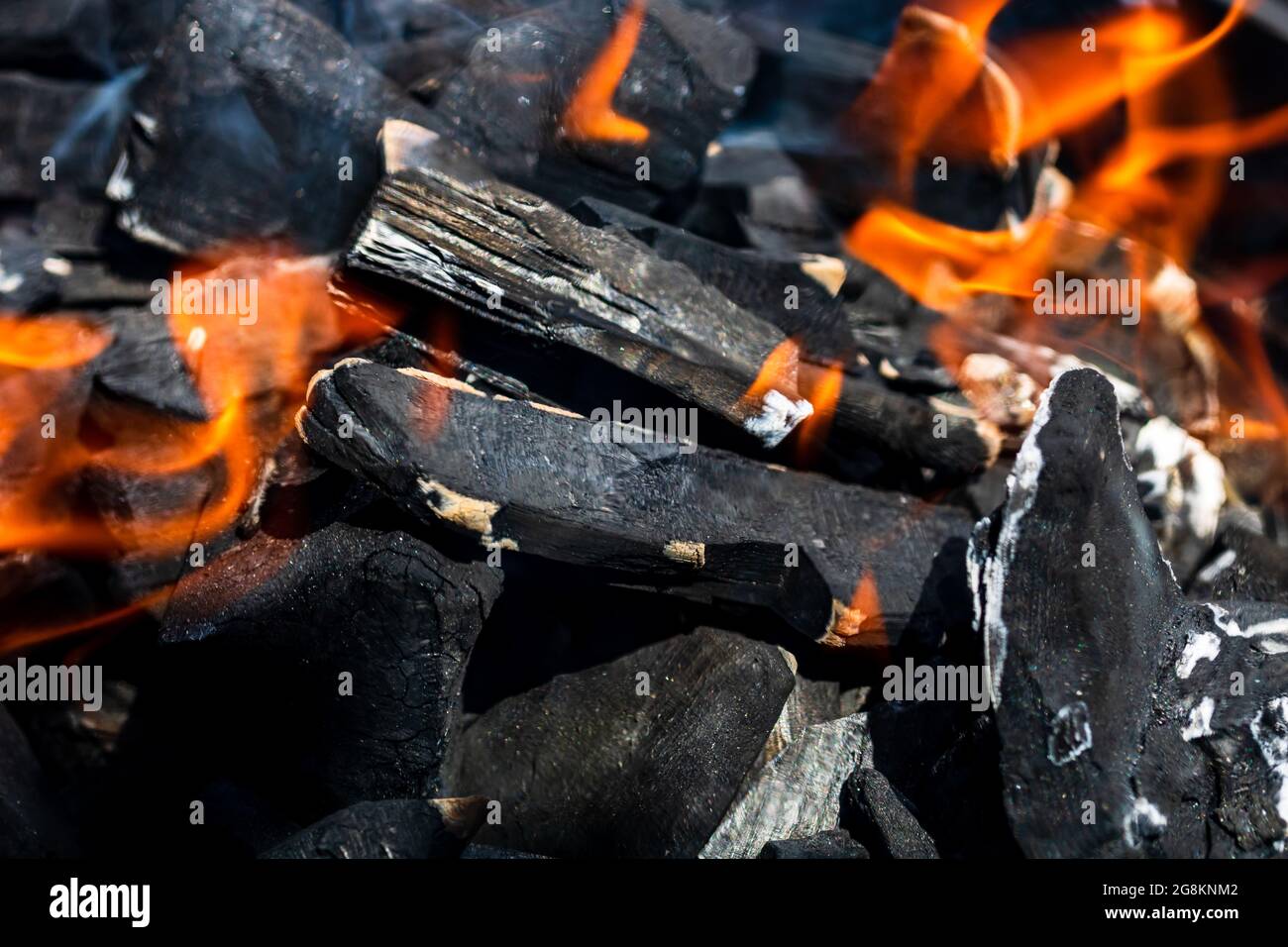 Barbecue grill pit with glowing and flaming hot charcoal briquettes