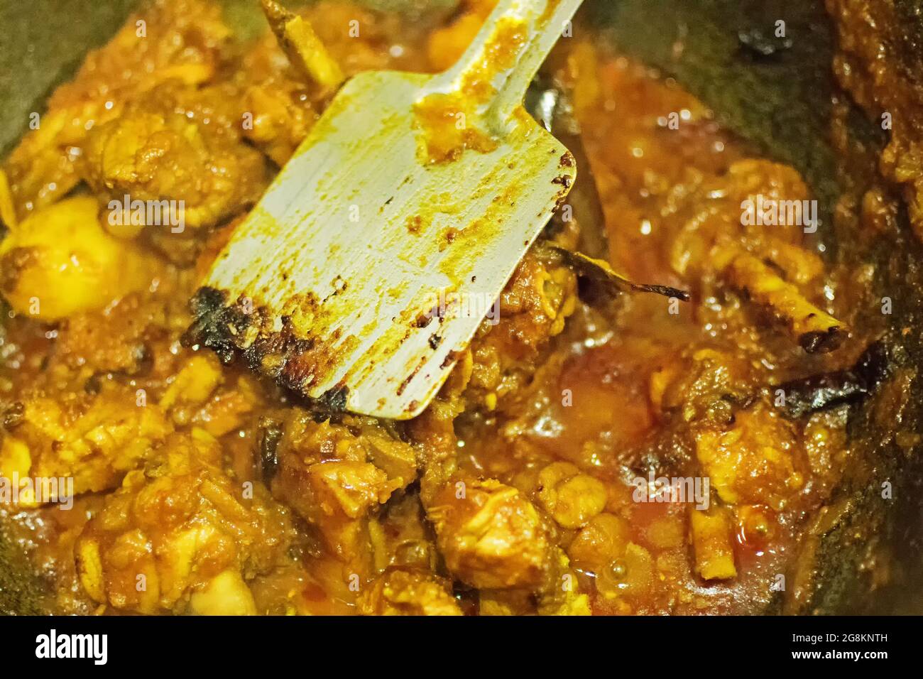 Preparation of smoking hot Indian chicken curry, one of the spicy delicacies of Indian foods. India is famous for such colorful tasty foods in Asia. Stock Photo