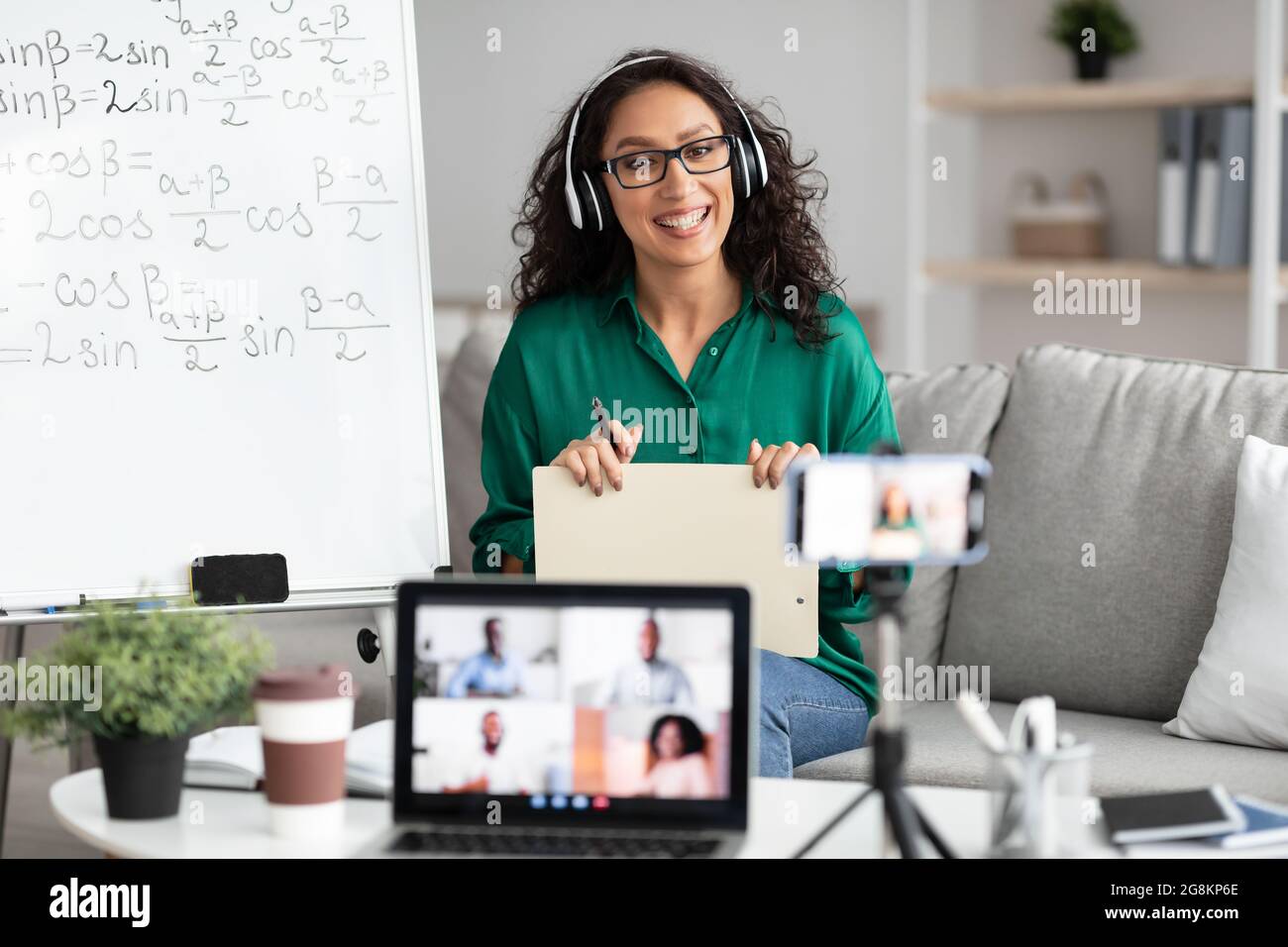 Female teacher giving online lecture to students recording video Stock