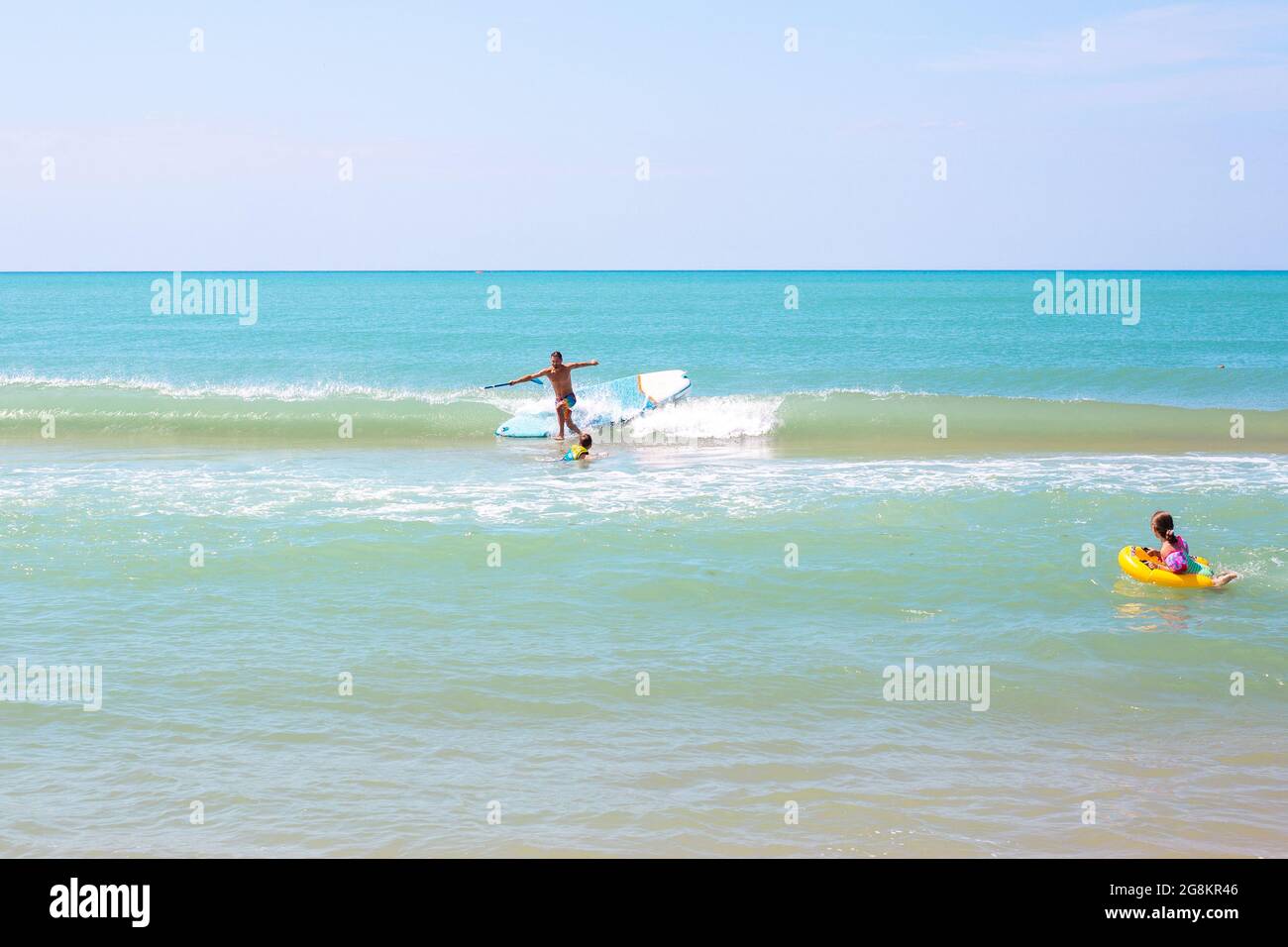 Anapa, Russia-07.07.2021: Tourist swims in the sea and surfs, falls off the board. Get on your surfboard and practice. Stock Photo