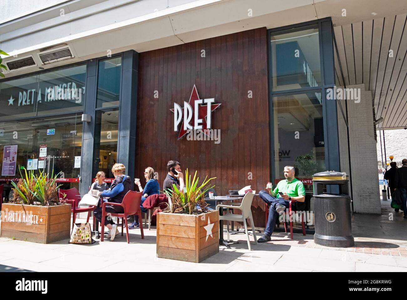 Pret a Manger exterior sign people social distancing sitting at tables during covid pandemic outside restaurant in London UK   KATHY DEWITT Stock Photo