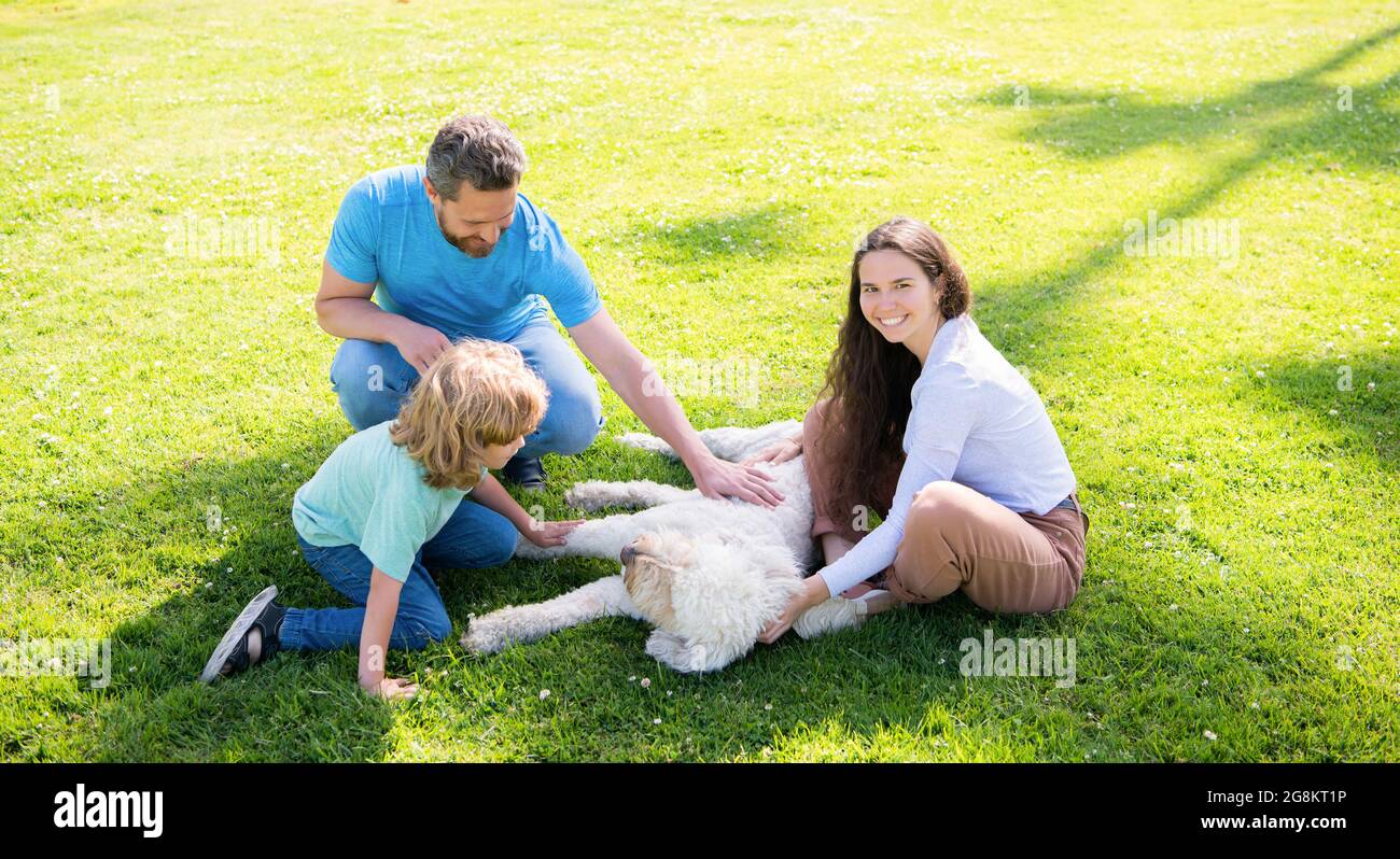 happy parents with kid boy play with dog. mom dad and son love relax together. Stock Photo