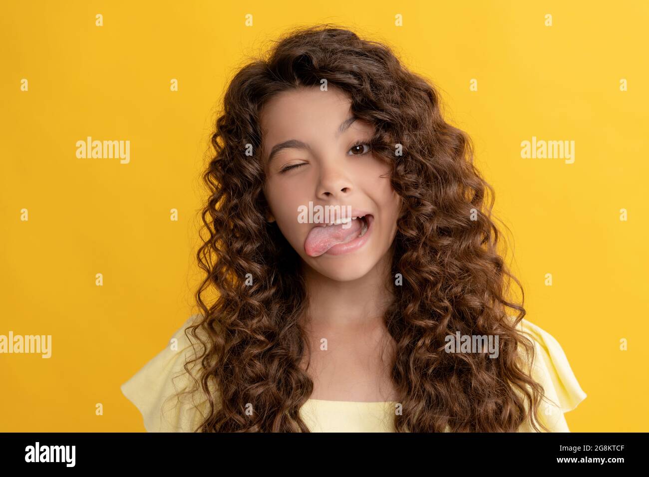 funny child with long curly hair and perfect skin showing tongue, fashion Stock Photo
