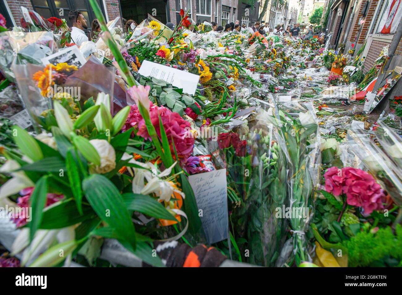 Floral tributes, messages and cards for murdered investigative journalist Peter R. de Vries seen on Leidsedwarsstraat street where he was shot. Dutch Crime investigative reporter Peter de Vries (64), was pronounced dead after a near fatal shooting on 6th July on Leidsedwarsstraat in Amsterdam. The reporter had always declined the protection of bodyguards. A statement from his relative had read: 'Peter has lived by his conviction: “On bended knee is no way to be free'.' Peter de Vries, had won critical acclaim for his reporting on the Dutch underworld, this included the 1983 kidnapping of the b Stock Photo