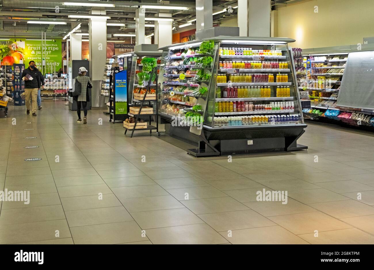 M&S Marks and Spencers store interior with empty floorspace and very few people customers during the covid 19 pandemic in the City of London UK 2021 Stock Photo