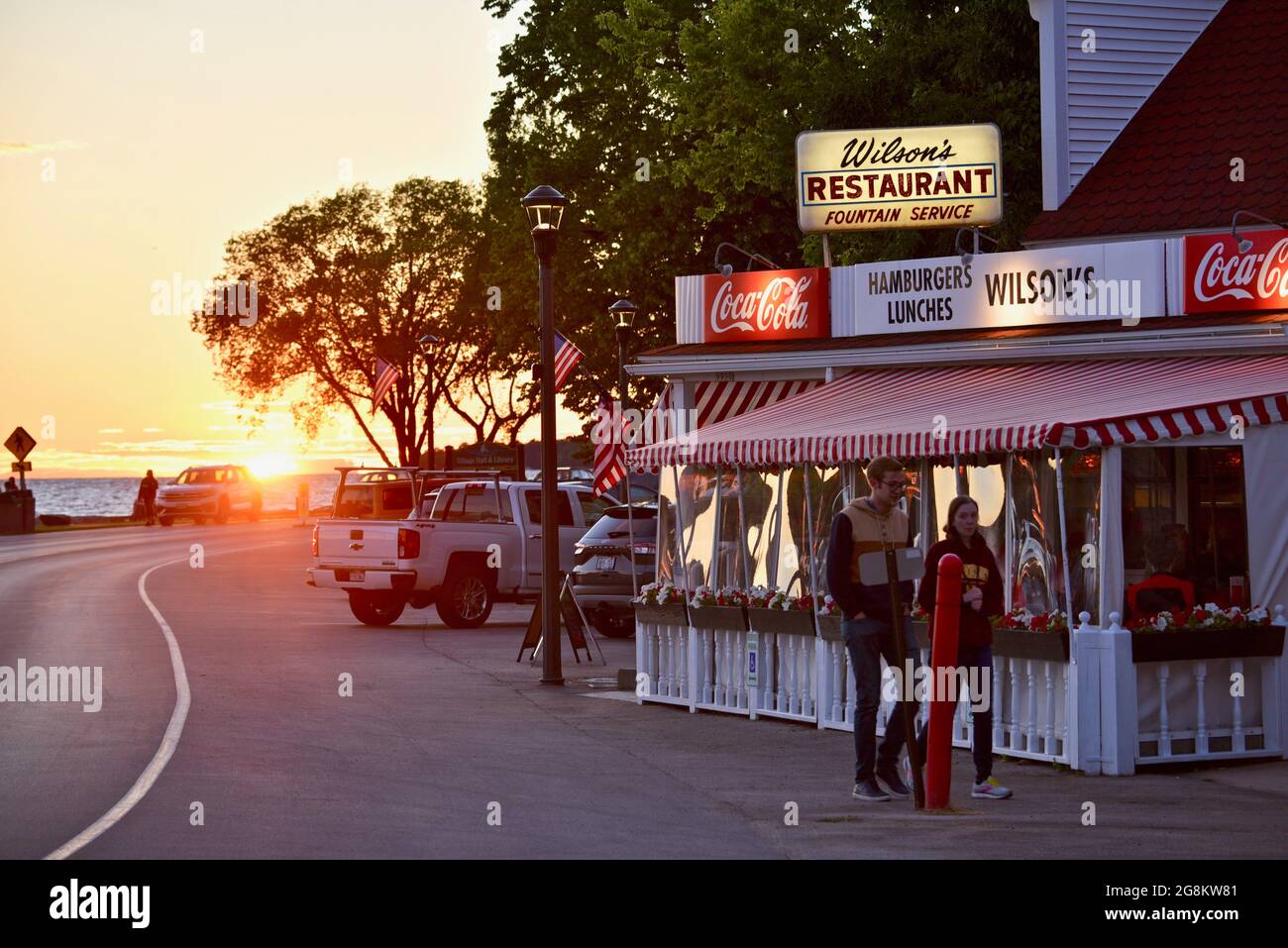 Magnificent golden sunset reflecting off road with tourists going to