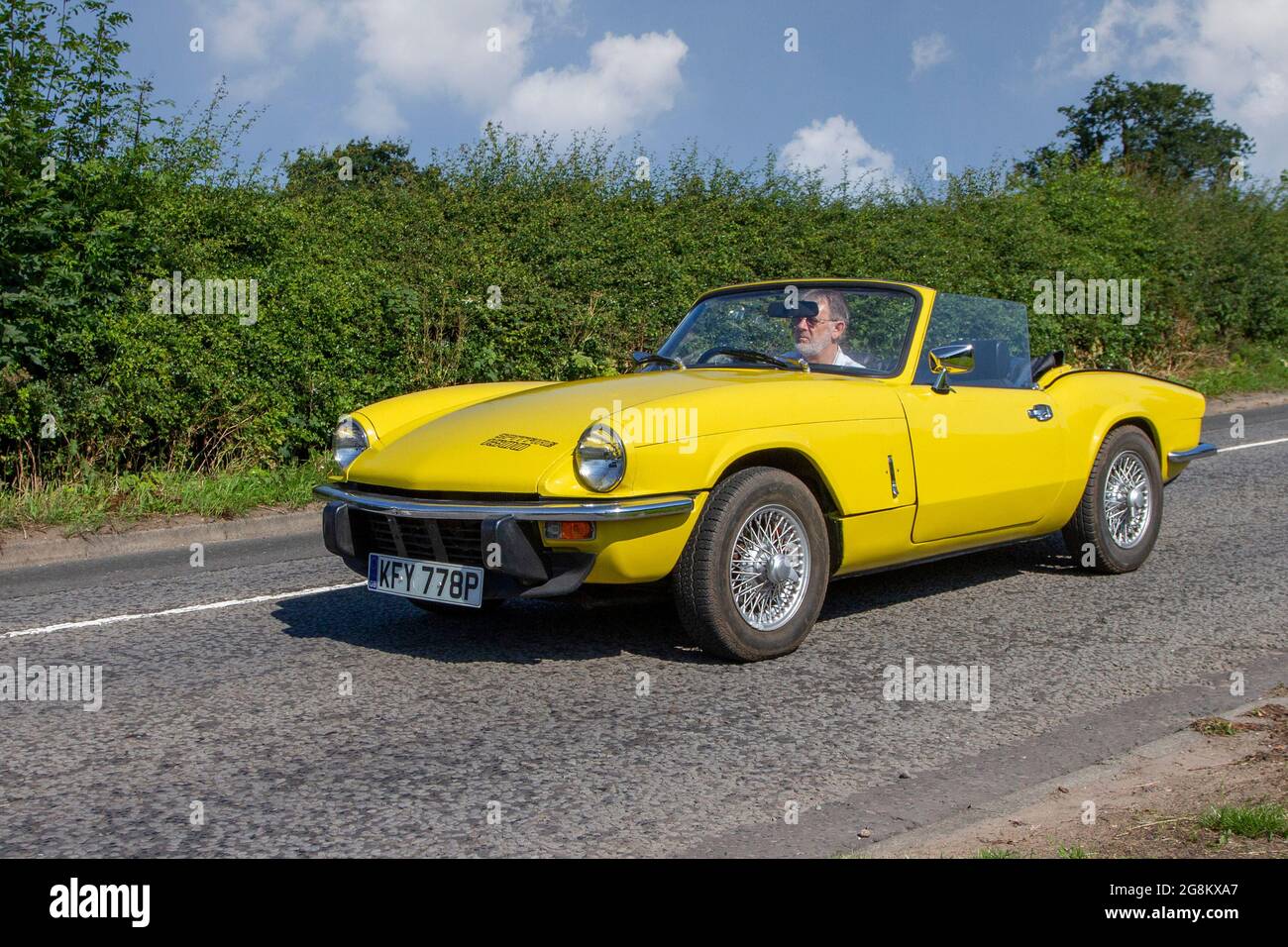 1976 70s yellow British Triumph Spitfire sports car cabrio, British front-engined, rear-wheel drive, two-passenger convertible, en-route to Capesthorne Hall classic July car show, Cheshire, UK Stock Photo