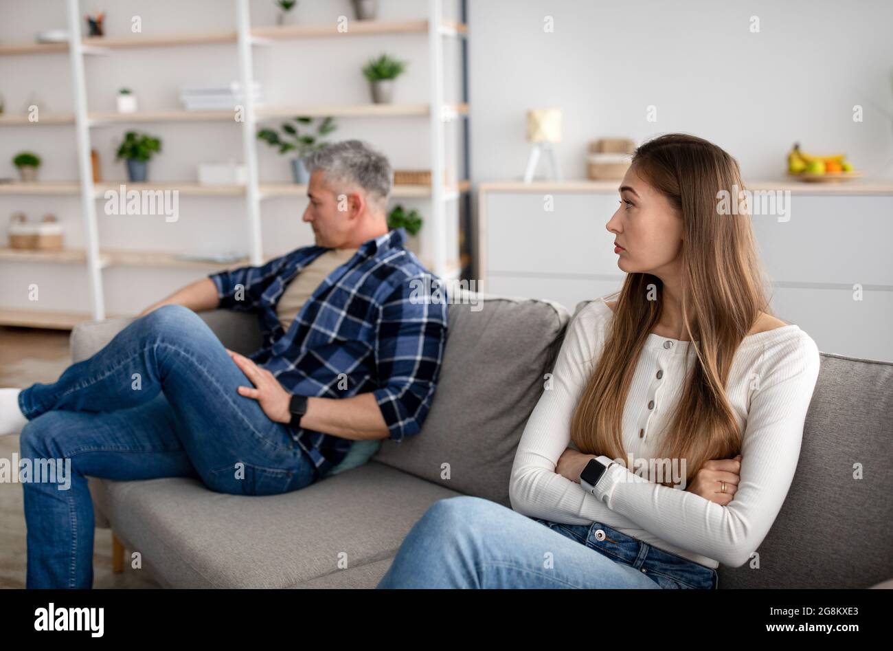 Upset Mature Woman And Her Husband Sitting Apart On Couch At Home After