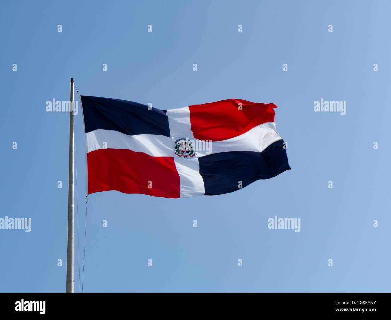 The Dominican flags waving with blue sky in the background Stock Photo