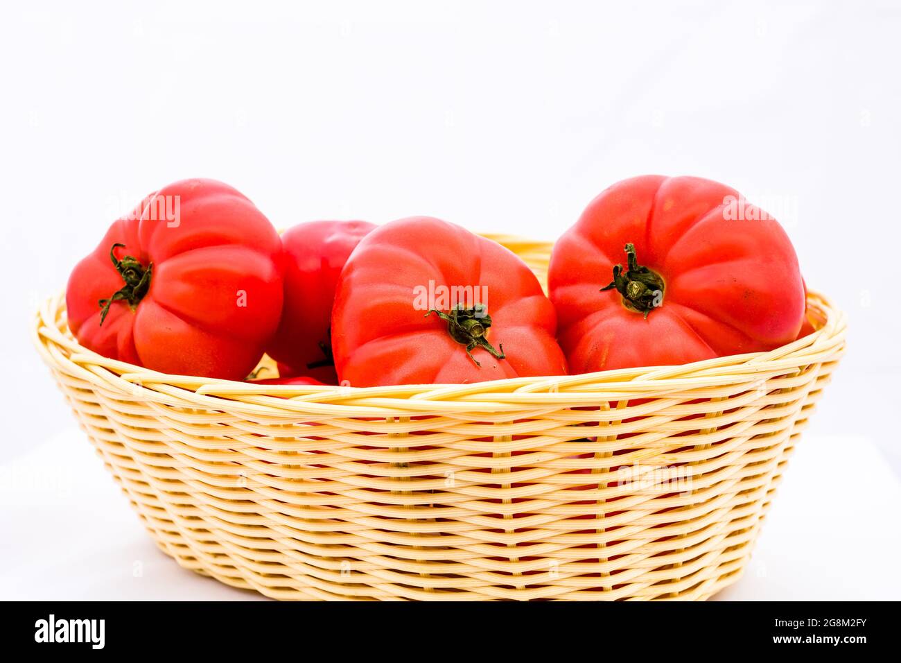 Fresh ripe tomatoes in wicker basket isolated on white background Stock ...