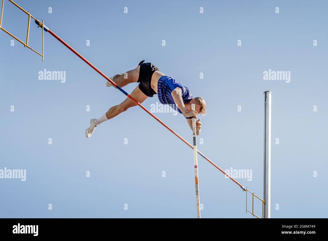 male athlete pole vault on blue sky background Stock Photo Alamy