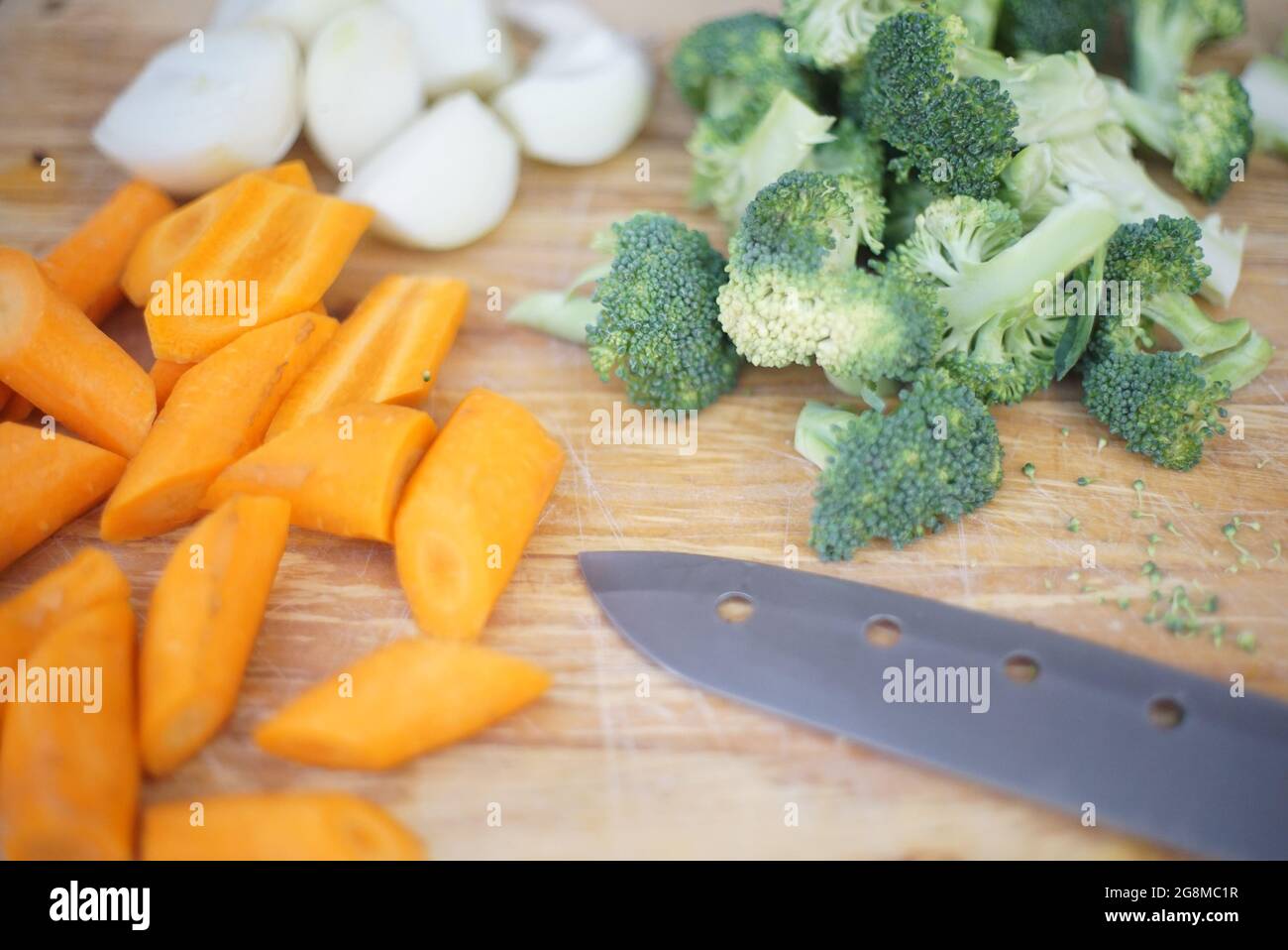 Cut vegetables on a chopping board with knife Stock Photo