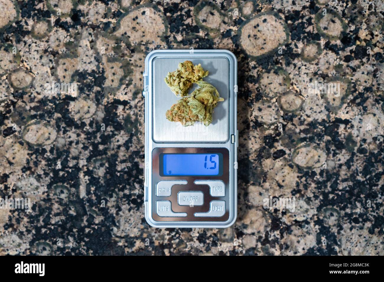 https://c8.alamy.com/comp/2G8MC3K/weighing-the-dose-of-marijuana-using-a-digital-scale-on-a-marble-table-2G8MC3K.jpg