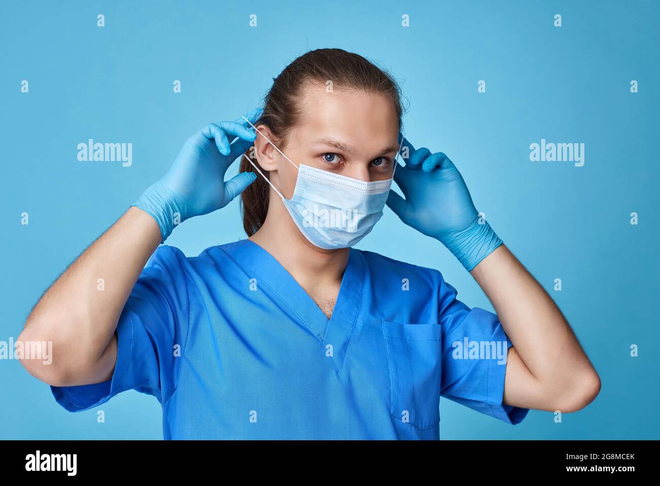 young man doctor in uniform wearing mask Stock Photo