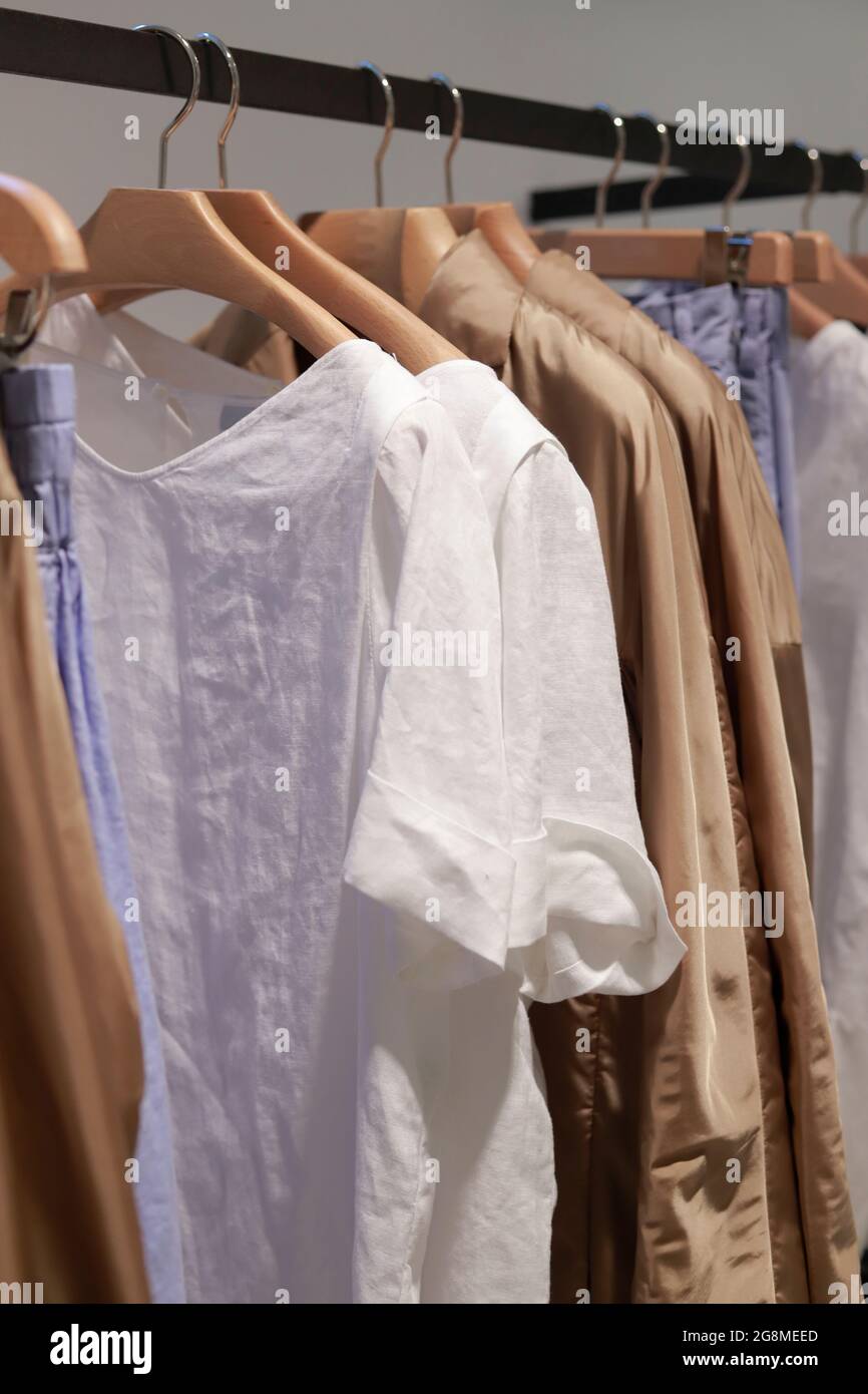 summer clothes in tent with wooden hangers Stock Photo