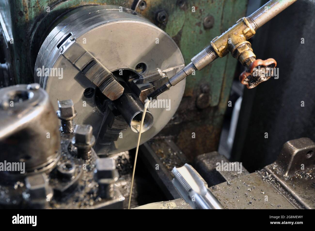Cutting a thread in a workpiece. Cooling lubricant supply. Stock Photo