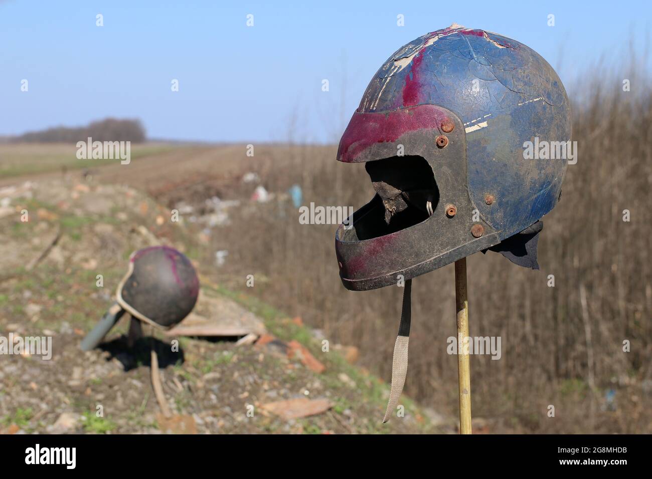 Old motorcycle helmet on a stick sticking out of the ground Stock Photo