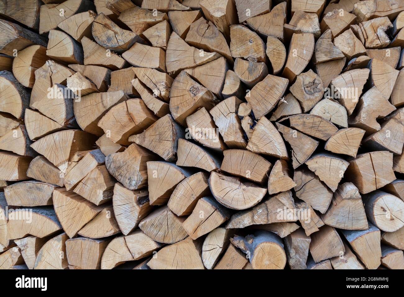 Neatly folded, chopped firewood. Harvesting firewood for the winter, preparing for the heating season. Stock Photo
