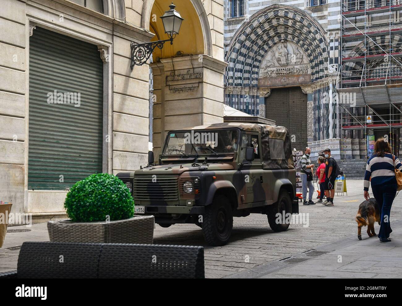 Reconnaissance car Land Rover Defender of the Italian army patrolling the historic centre of Genoa with the Cathedral of St Lawrence in the background Stock Photo