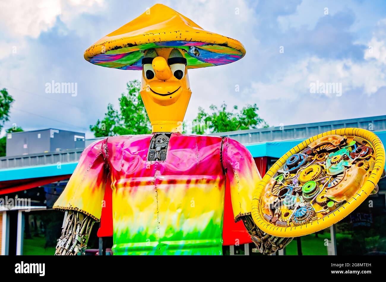 A giant scrap metal man holds a pizza in front of Mellow Mushroom, July 20, 2021, in Mobile, Alabama. Stock Photo