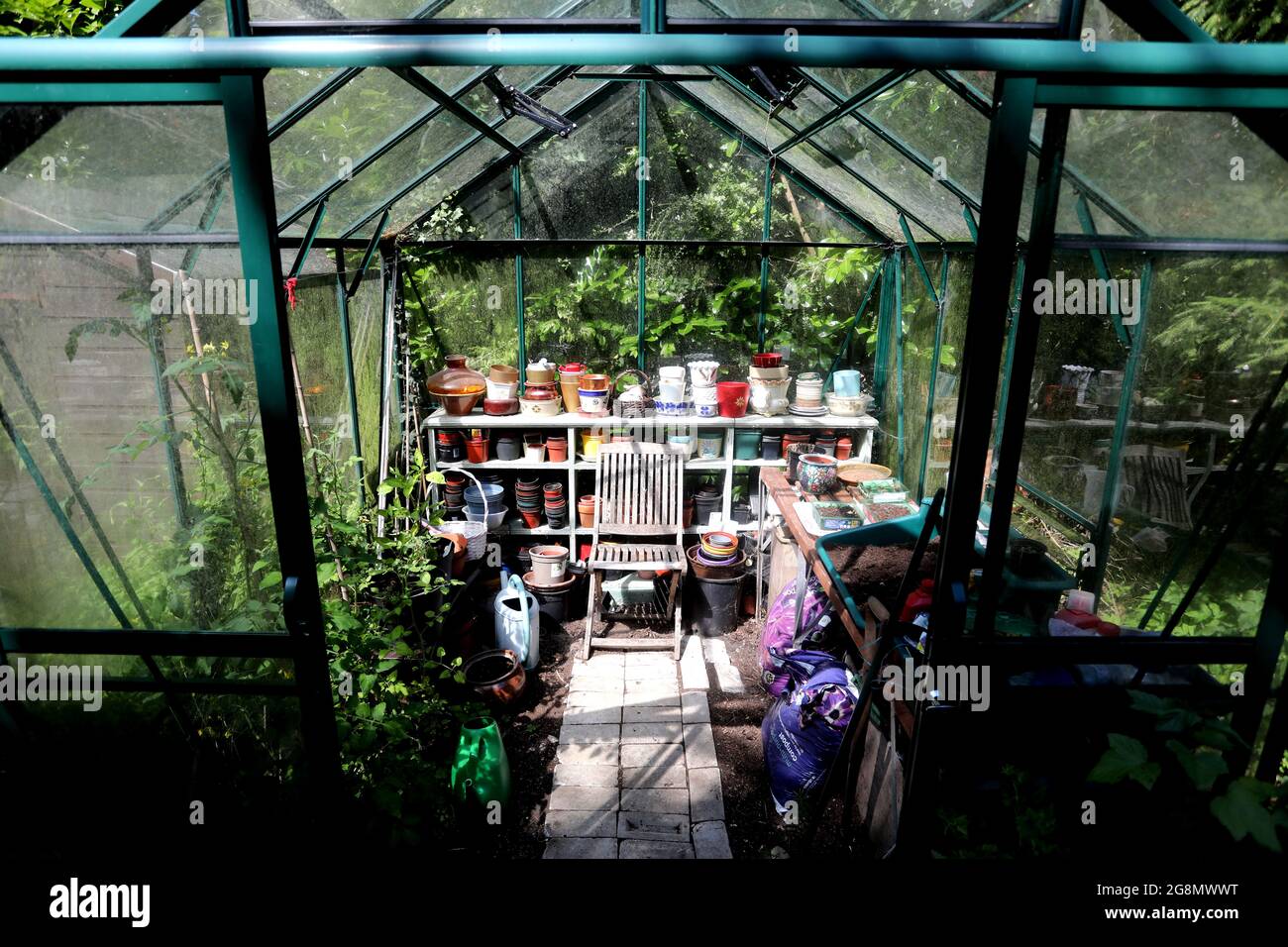 General view of a lovely looking greenhouse in a garden in West Sussex, UK. Stock Photo