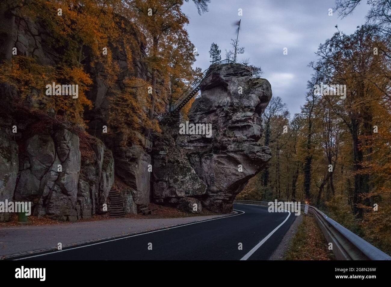 road through Mullerthal at autumn evening with rock formation near Berdorf, Luxembourg Stock Photo
