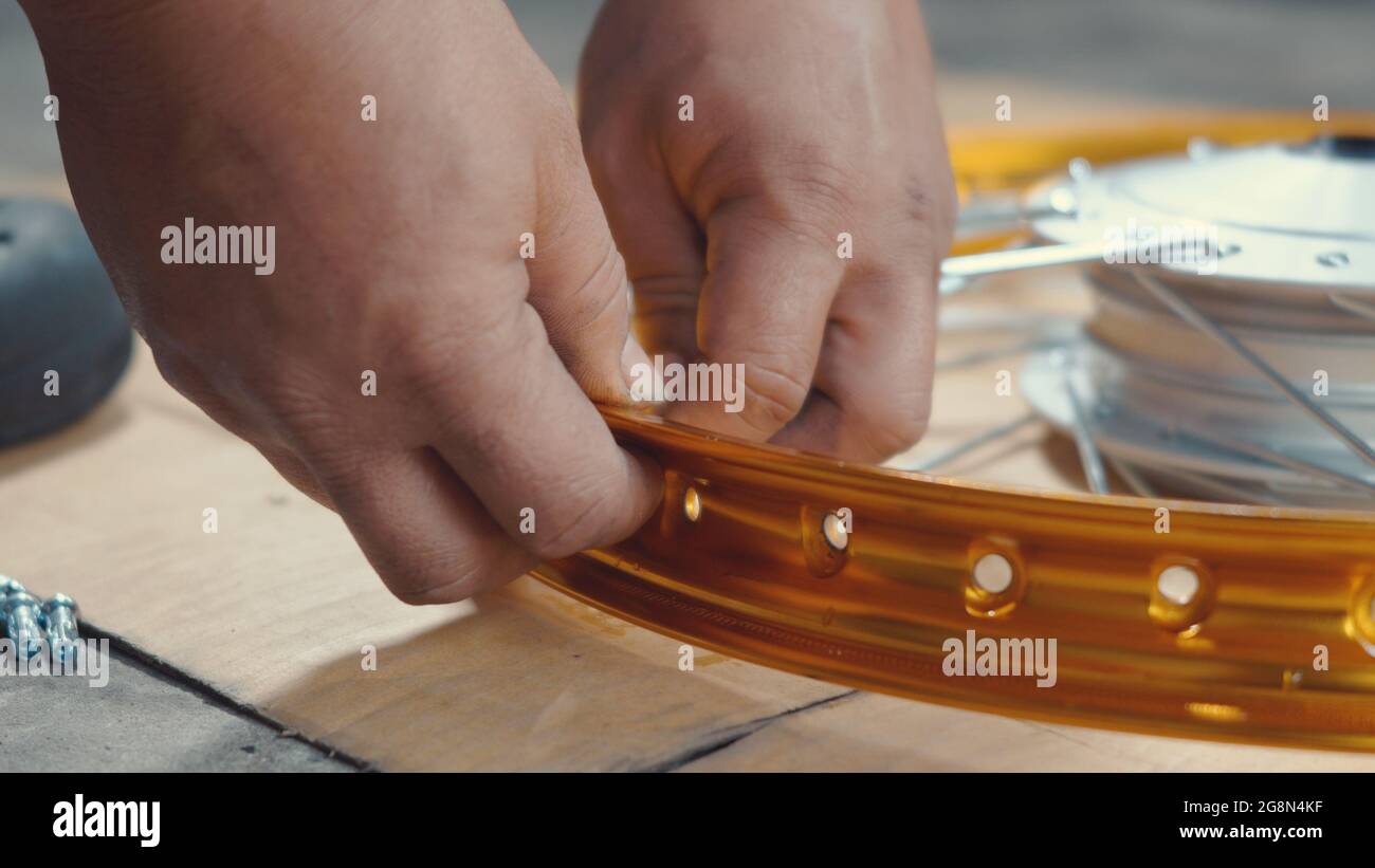 Technician man working motorcycle wheel has spokes weave up on mechanic