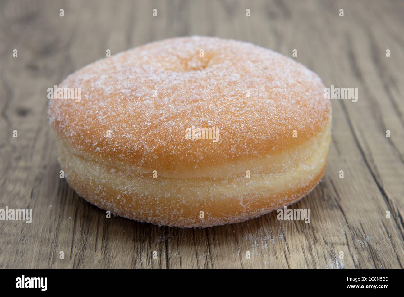 Sugar raised round donut is textured with sugar coating for a sweet treat delight. Stock Photo