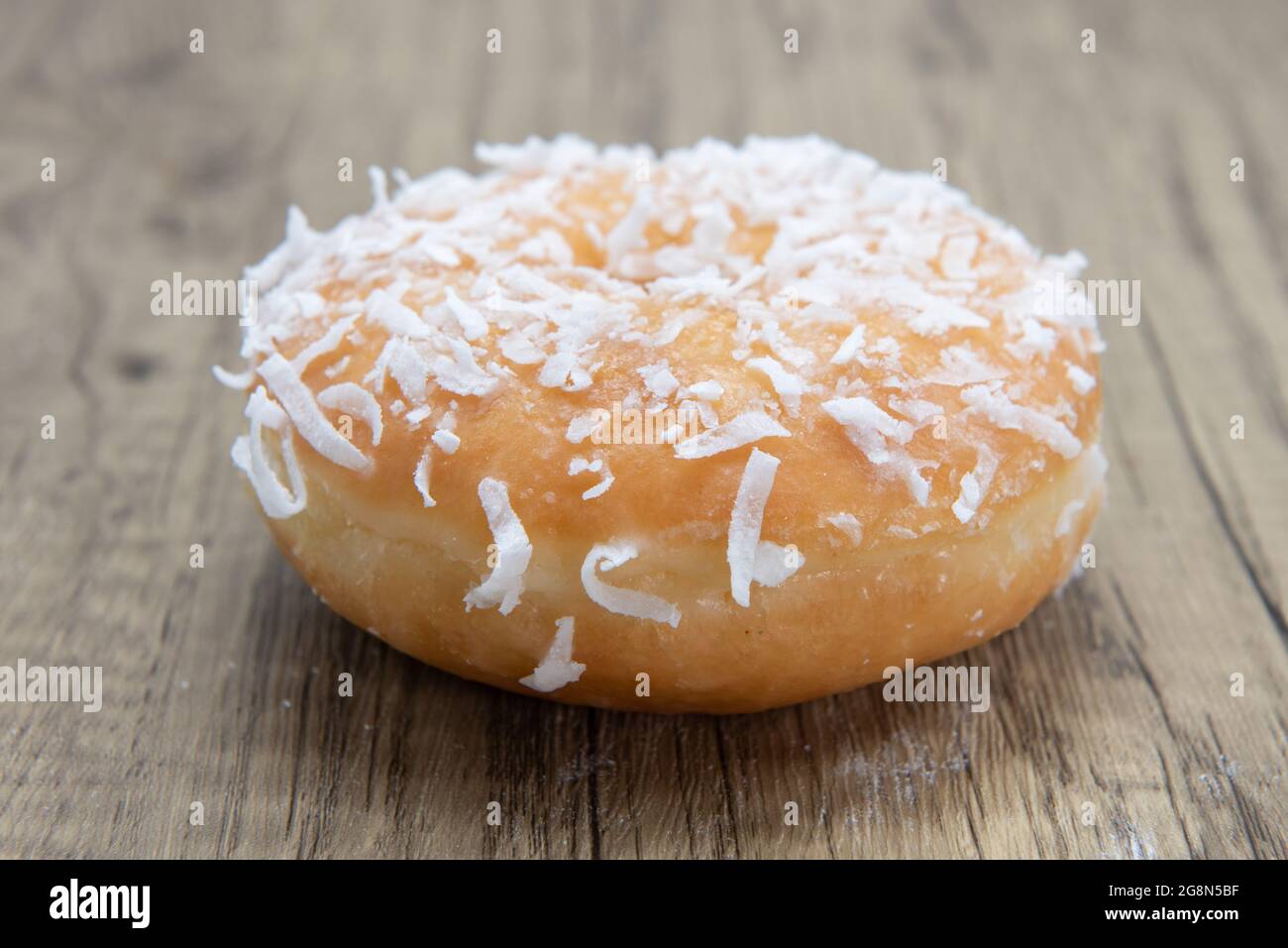 Cocnut raised  donut is textured with glazed coating for a sweet treat delight. Stock Photo