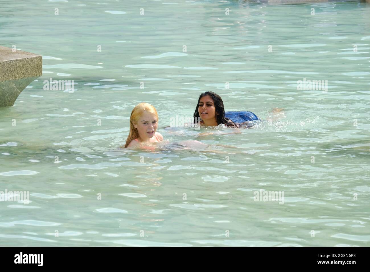 Teenagers take a dip in Trafalgar Square fountains during the recent heatwave when the Met Office issued an extreme heat warning. Stock Photo