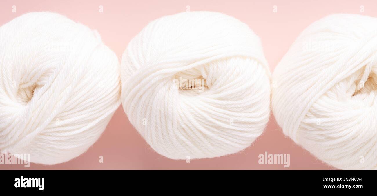 White clews of wool on a pink background. Top view. Close-up - Image Stock Photo