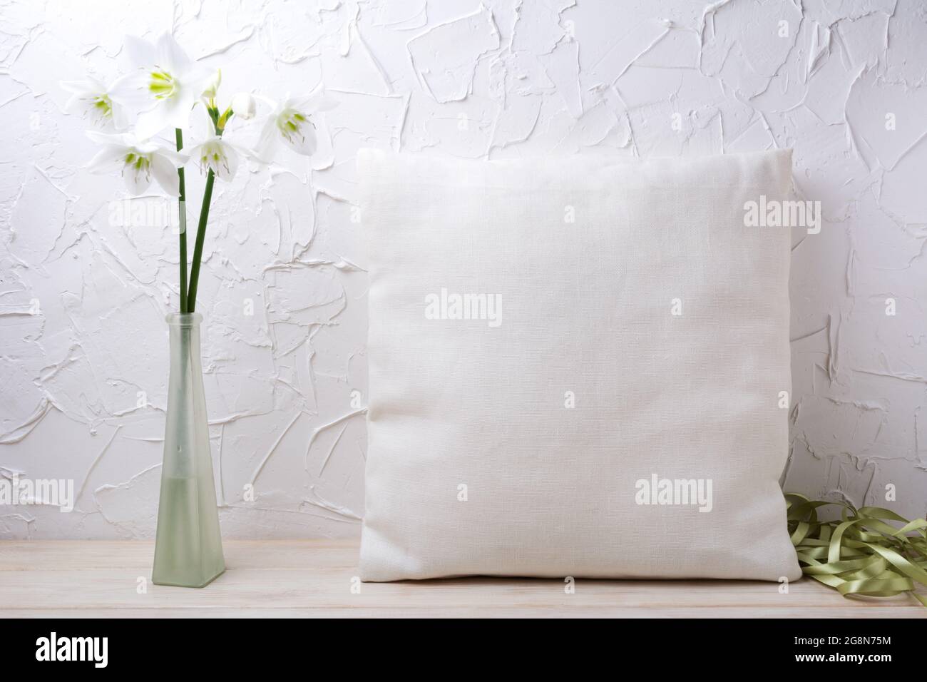 Square cotton pillow mockup with white lily flowers in the glass vase
