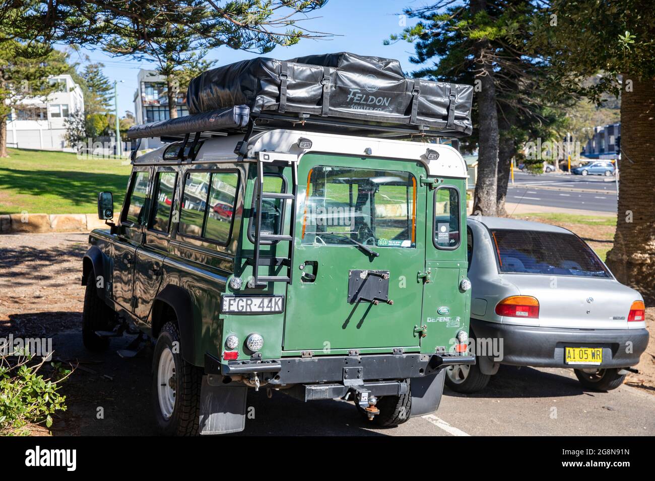 Green Land Rover Defender 110 vehicle with roof rack parked in Sydney,NSW,Australia Stock Photo