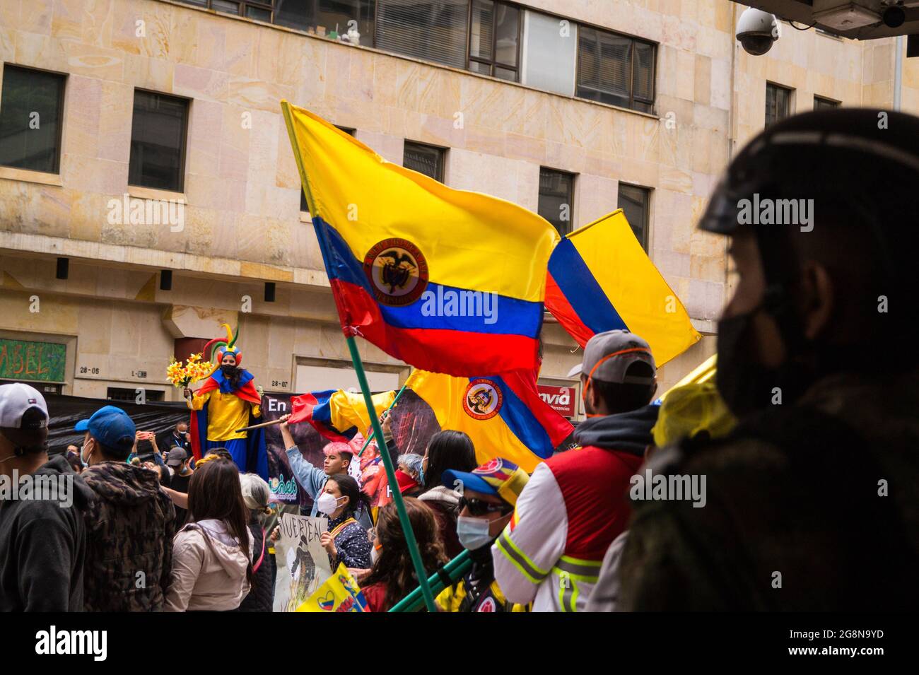 Demonstrators wave Colombian flags during a new day of anti-government protests during the 211 celebration of Colombia's independence from spain, protests raised into clashes in various cities after intervention by Colombia's riot police ESMAD, in Bogota, Colombia on July 20, 2021. Stock Photo