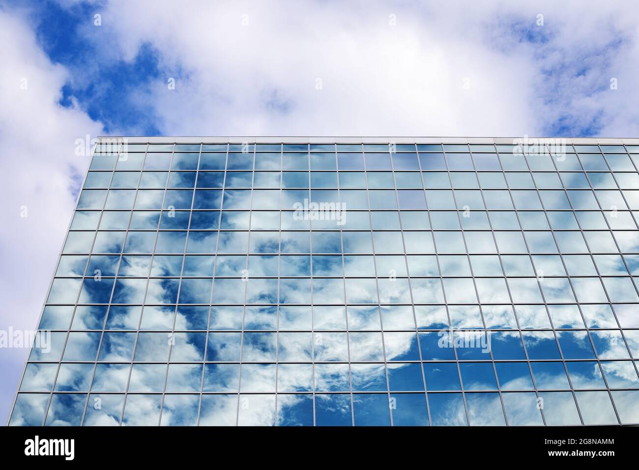 Reflection of blue sky with clouds in tall modern glass building in ...