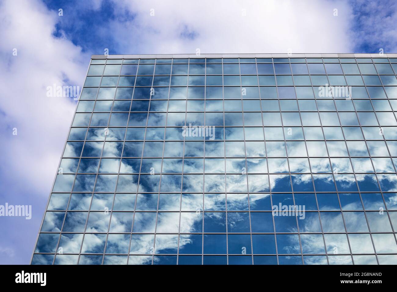 Reflection of blue sky with clouds in tall modern glass building in ...