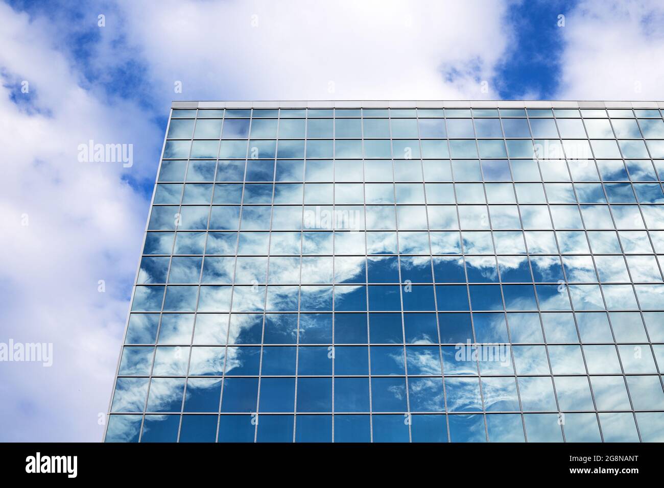 Reflection of blue sky with clouds in tall modern glass building in ...