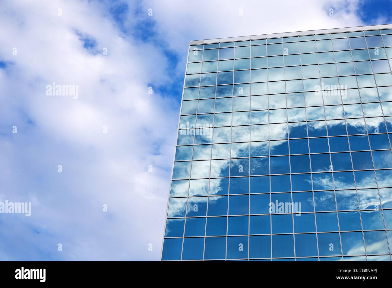 Reflection of blue sky with clouds in tall modern glass building in ...