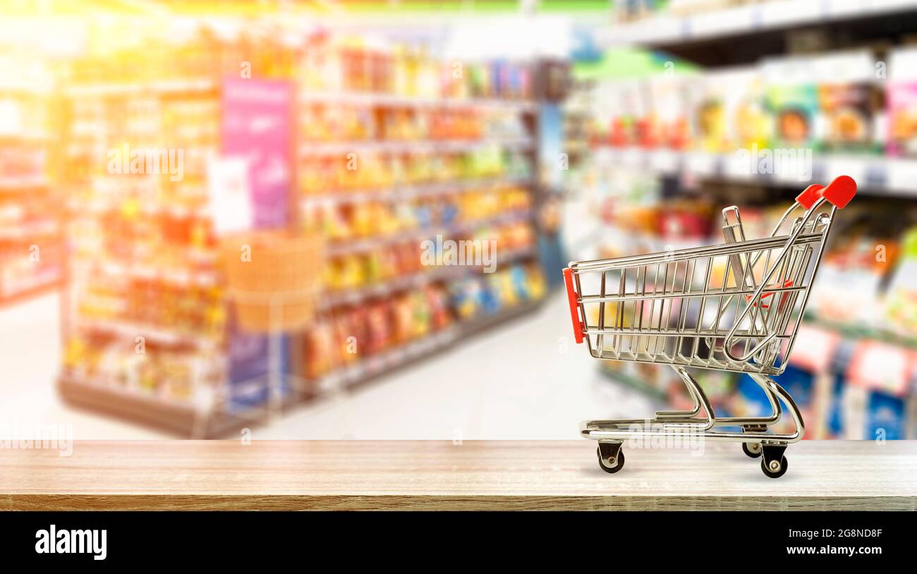 Supermarket grocery table background with cart. Food and groceries blurred  on store shelves. High quality photo Stock Photo - Alamy