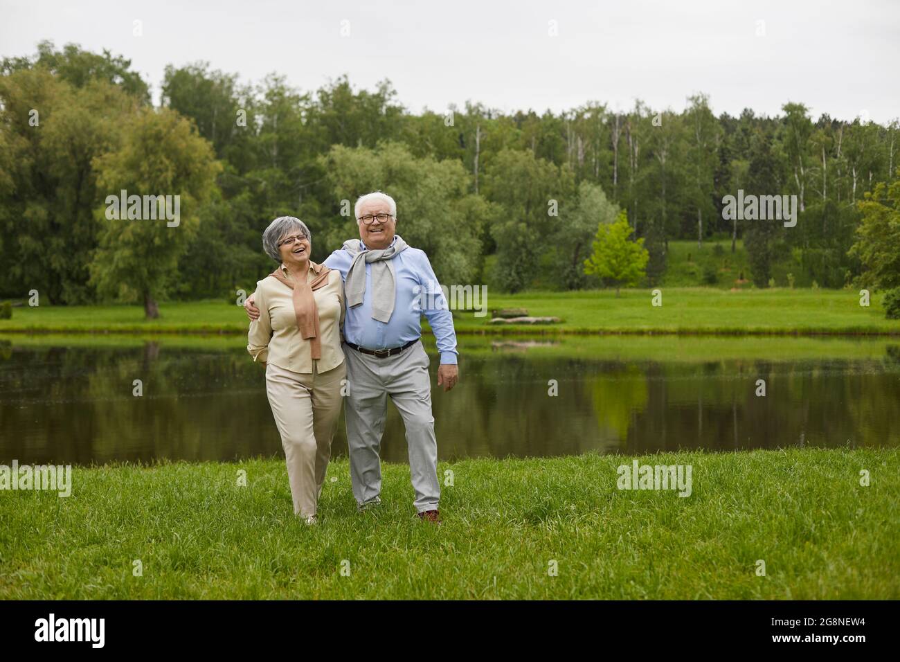 An elderly couple in casual clothes are walking outdoors Stock Photo