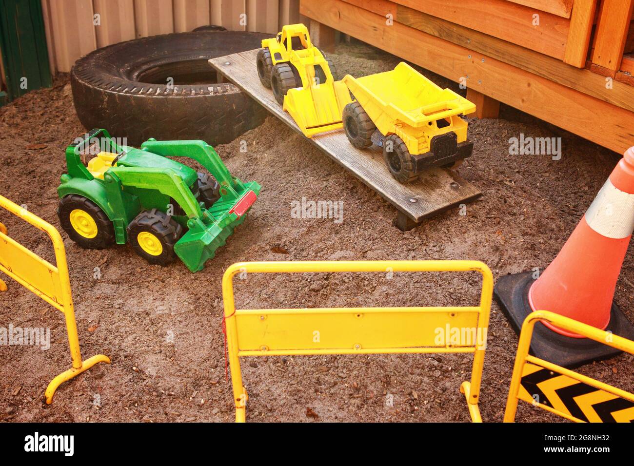 Toy diggers in an outdoor play construction site Stock Photo
