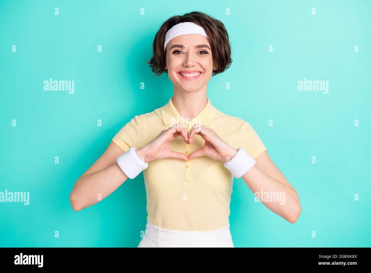 Photo of happy nice pretty young woman love sport make fingers heart figure isolated on teal color background Stock Photo