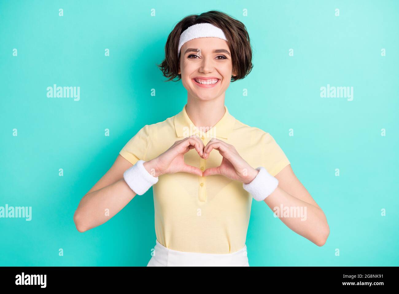 Photo of cheerful charming nice young woman make hands heart smile sport isolated on teal color background Stock Photo
