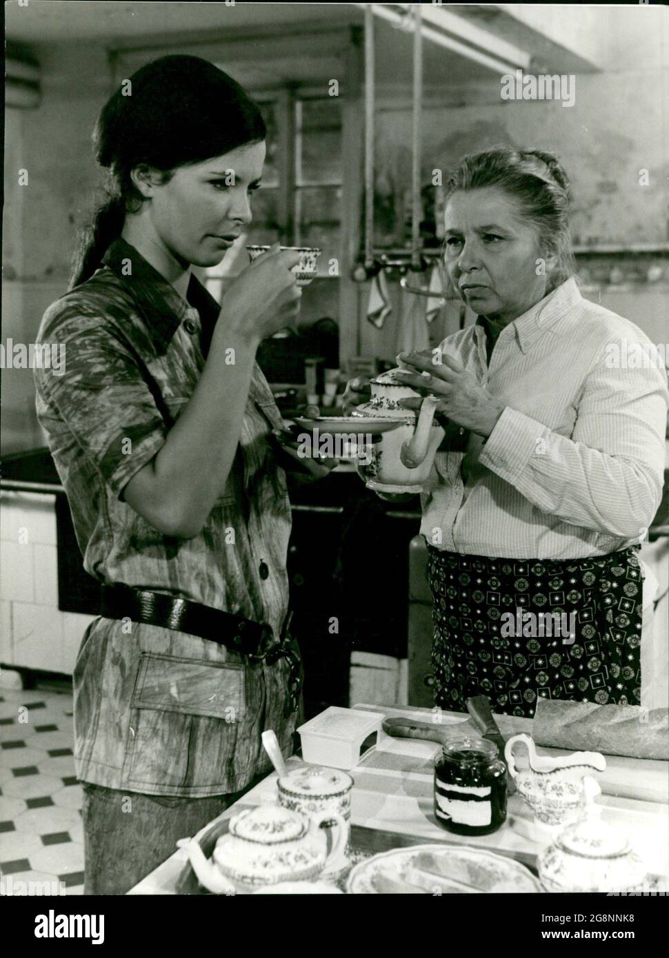 Tante Anna (Edith Schultze-Westrum) hat morgens in der Küche allerhand zu tun. Einer will Kaffee, der andere Tee, einer Spiegeleier, der nächste gekochte Eier. Mona (Marion Dulan) beschwichtigt sie. Alle sind ein bisschen nervös. Stock Photo