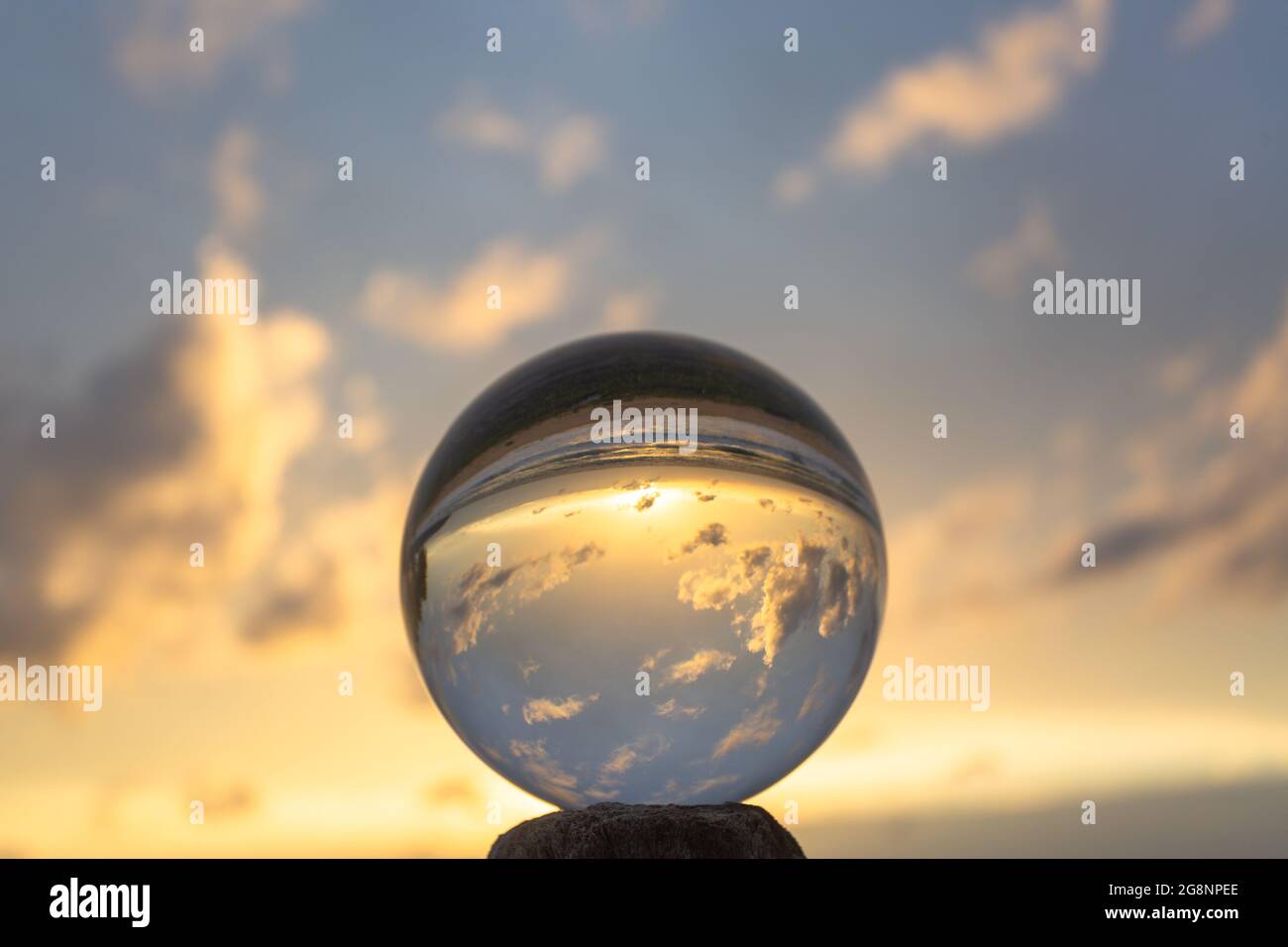 beautiful cloud and golden sunset inside crystal ball placed on a ...