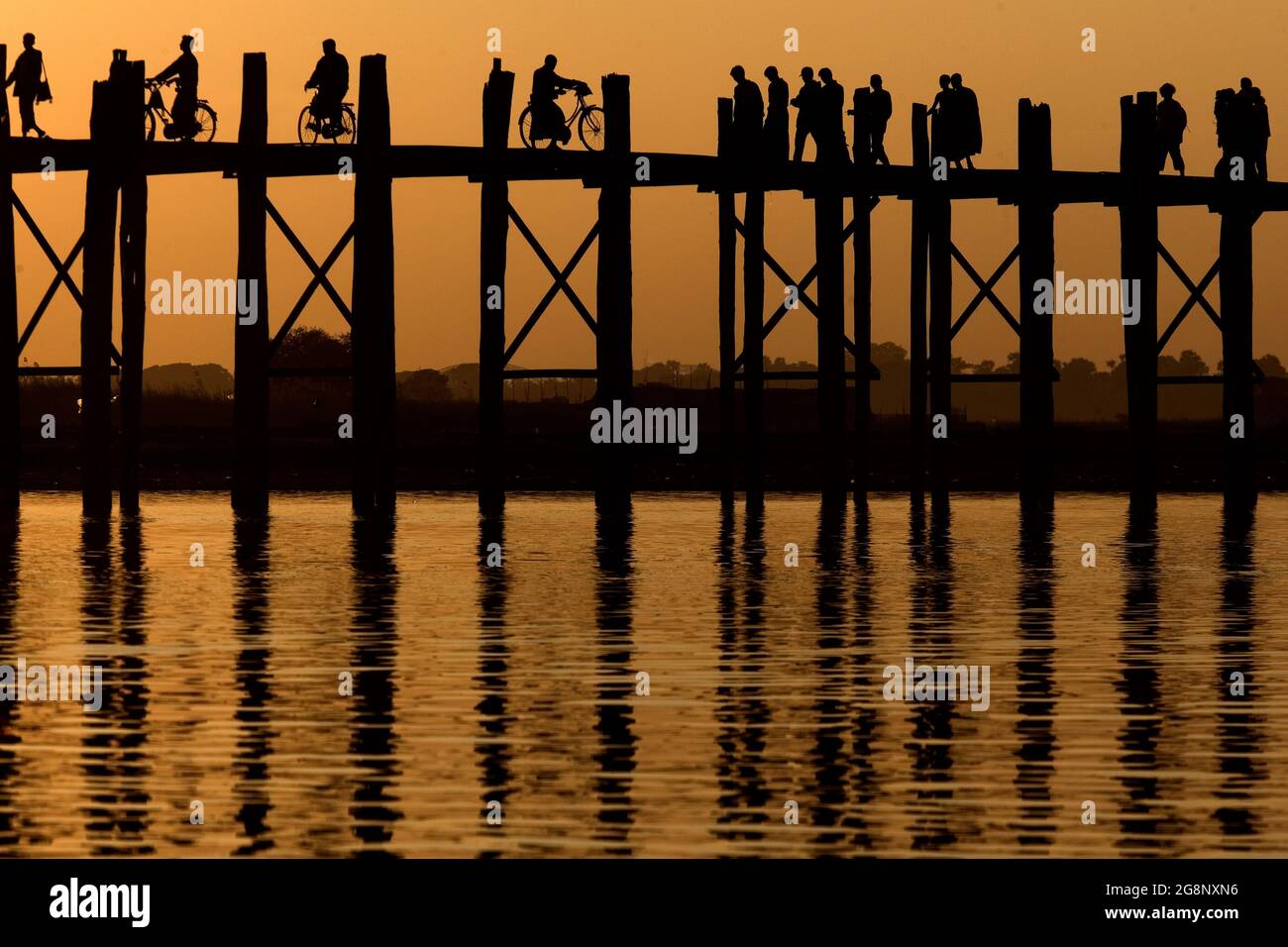 People crossing the U Bein teakwood bridge on Taungthaman lake at ...