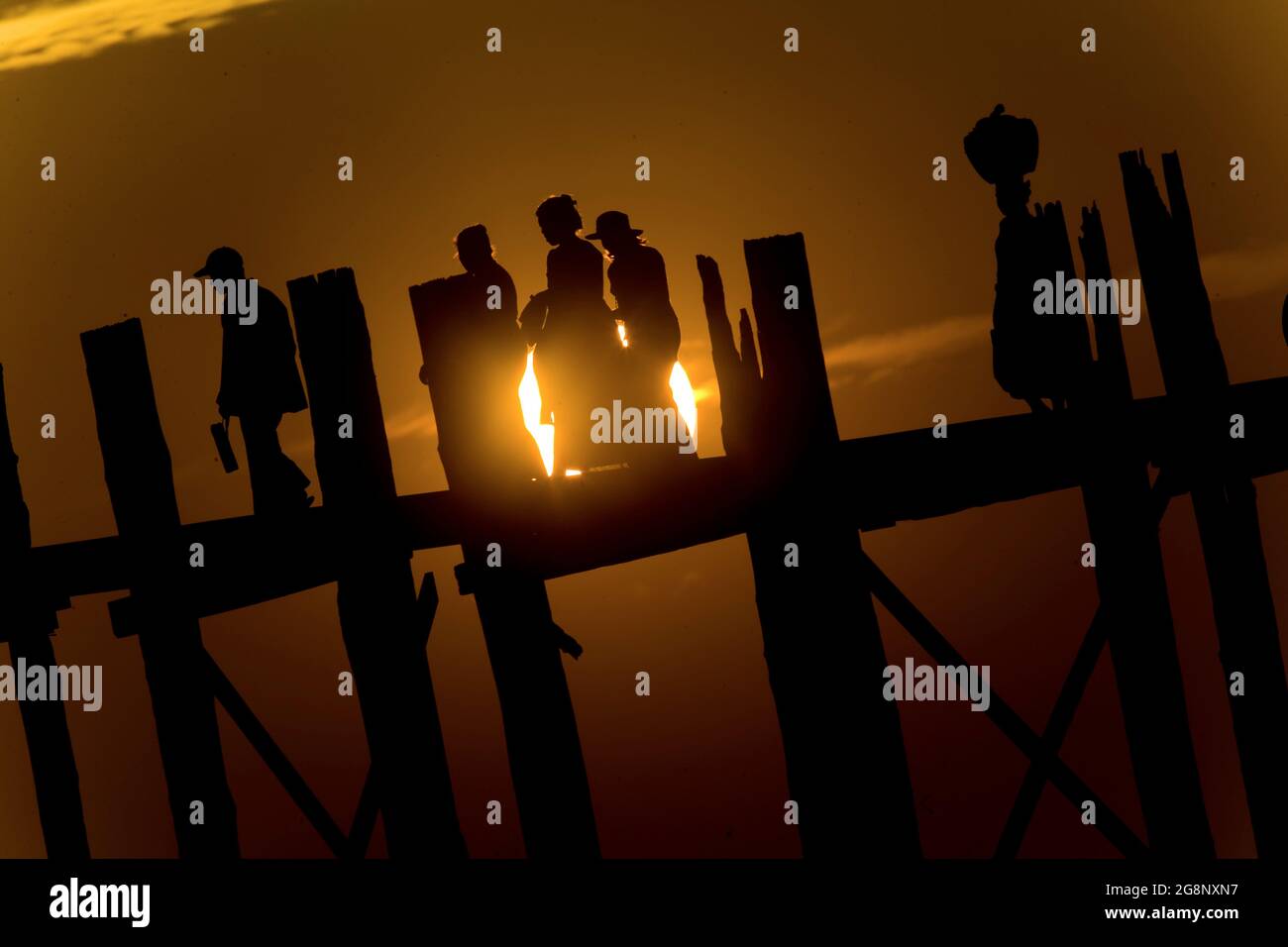 People crossing the U Bein teakwood bridge on Taungthaman lake at ...