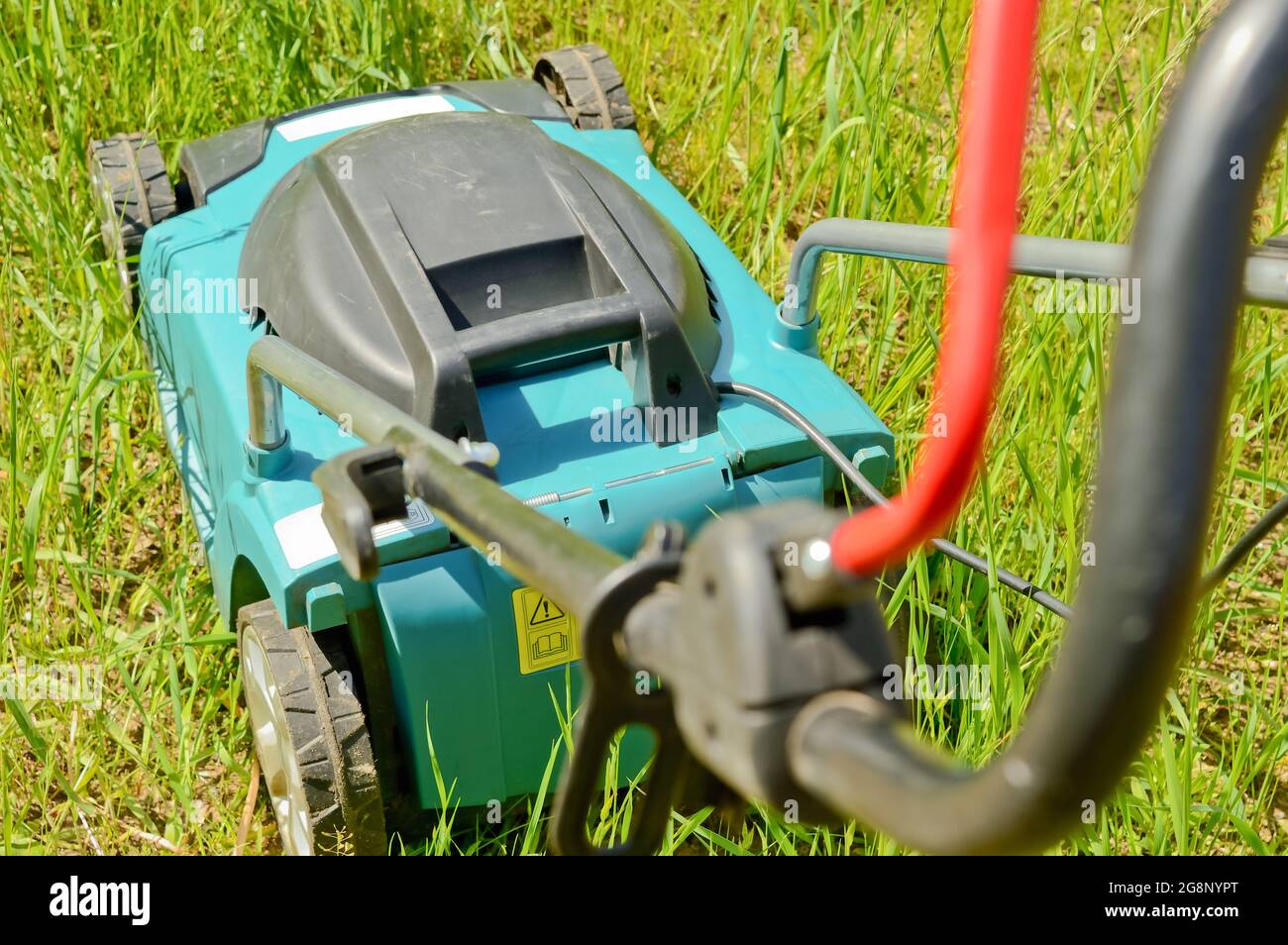 Top view of an electric lawn mower while mowing a grass and lawn Stock