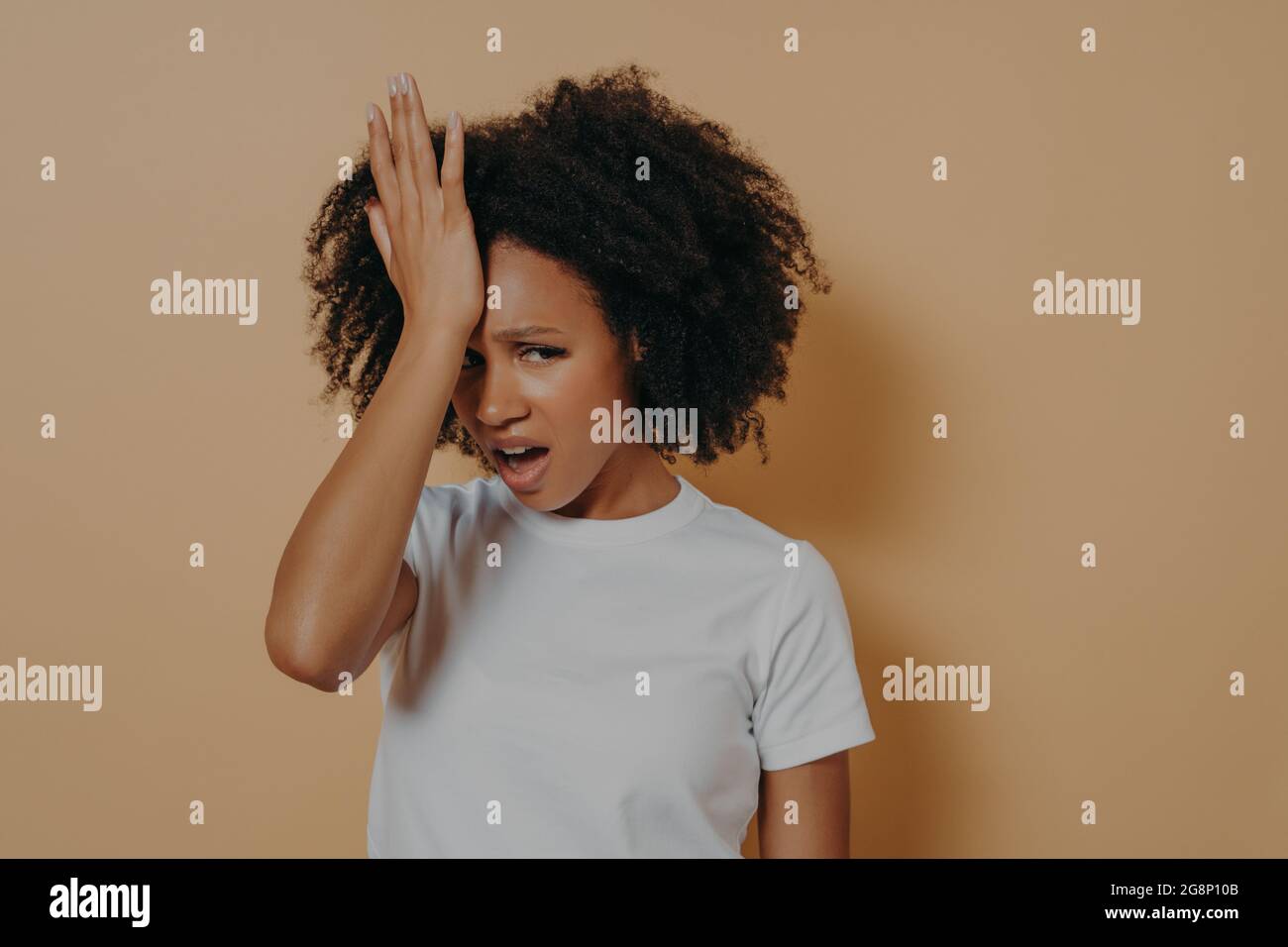 Young stressful african woman with hand on forehead suffering from strong headache or head migraine Stock Photo